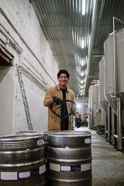 A Man Carrying Keg Containers